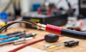 Przewody elektryczne z widoczną izolacją, zabezpieczone taśmą.