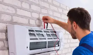 Technik sprawdza klimatyzację, która wydaje dziwny zapach z klimatyzacji w domu.