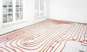 Instalacja ogrzewania podłogowego z rurkami w kolorze pomarańczowym. Widać, ile wody w podłogówce będzie krążyć, tworząc ciepło.