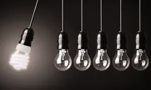 Wahadło Newtona z żarówką energooszczędną, która świeci, a obok niej wiszą żarówki tradycyjne. Czy to jest volt?