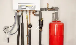 Instalacja grzewcza z kotłem i czerwonym naczyniem wzbiorczym. Prawidłowy dobór naczynia wzbiorczego to klucz do bezpiecznej pracy systemu.