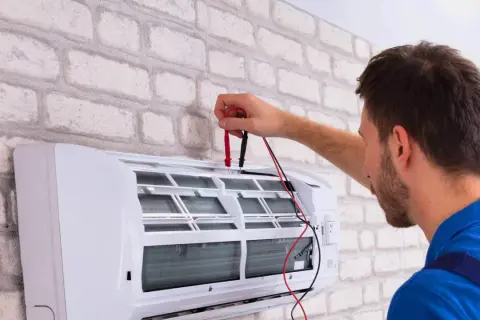 Technik sprawdza klimatyzację, która wydaje dziwny zapach z klimatyzacji w domu.