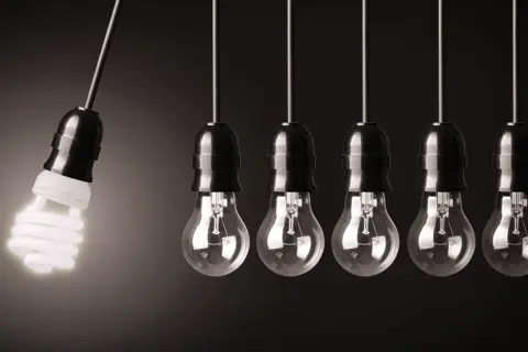 Wahadło Newtona z żarówką energooszczędną, która świeci, a obok niej wiszą żarówki tradycyjne. Czy to jest volt?
