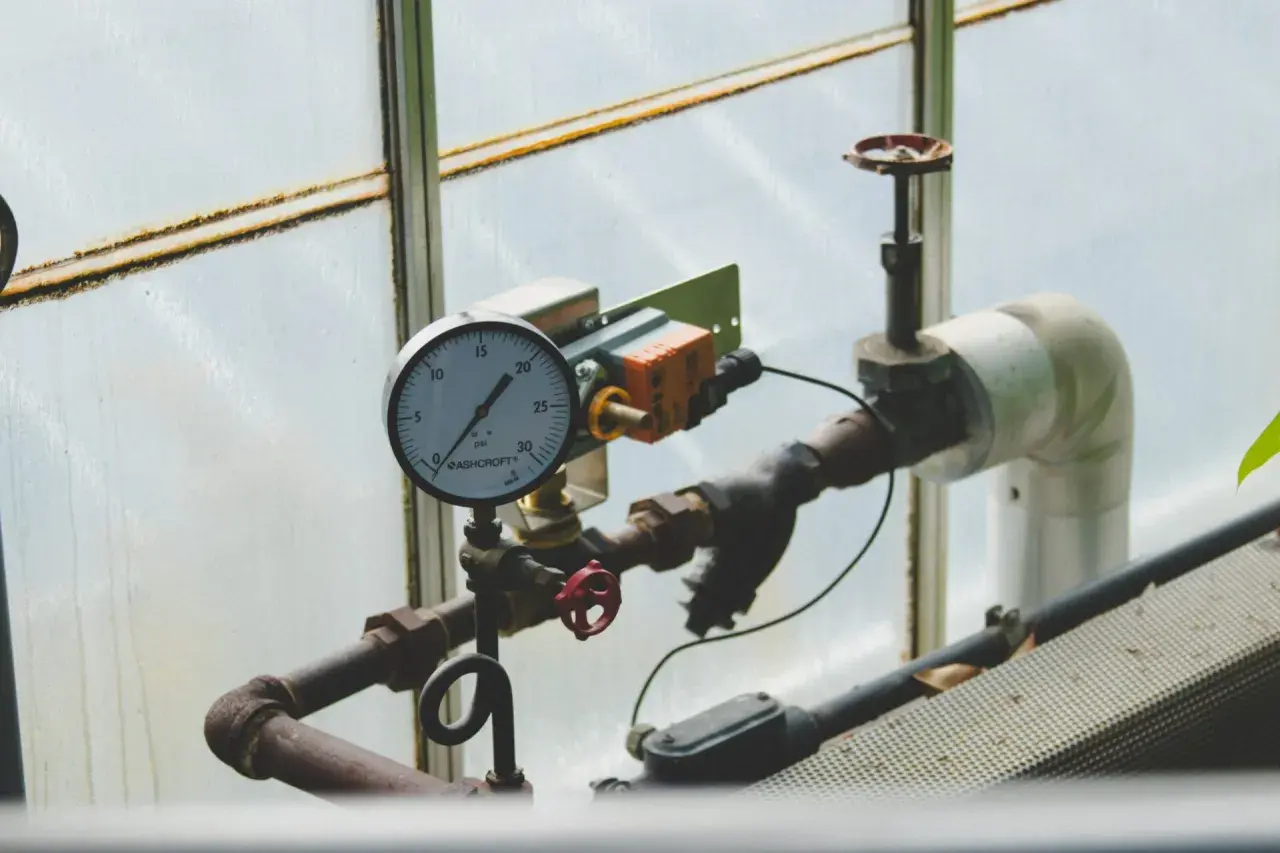 Manometr wskazuje prawidłowe ciśnienie w instalacji solarnej. Rury i zawory są częścią systemu.