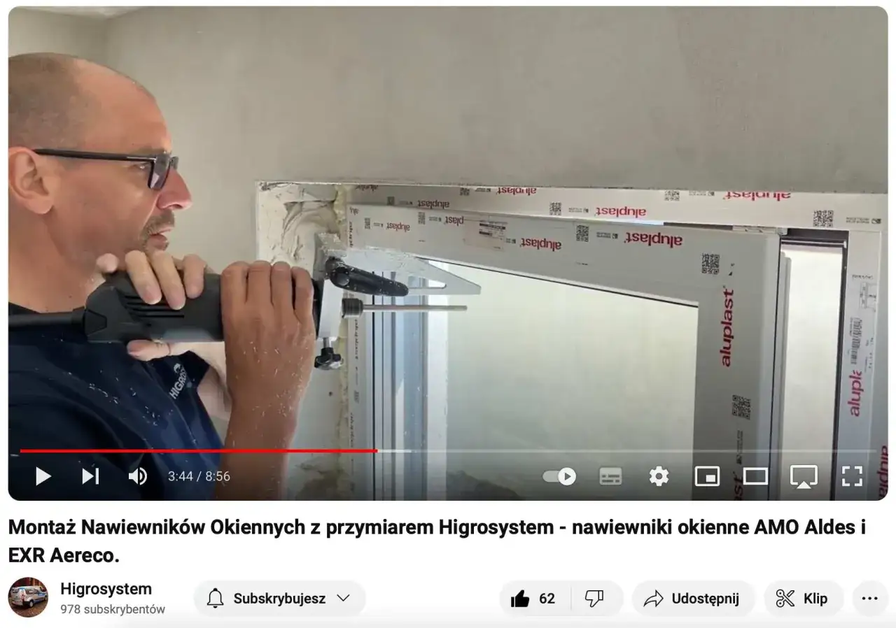 Mężczyzna wierci otw&oacute;r w oknie, pokazując, jak zamontować nawiewnik okienny.