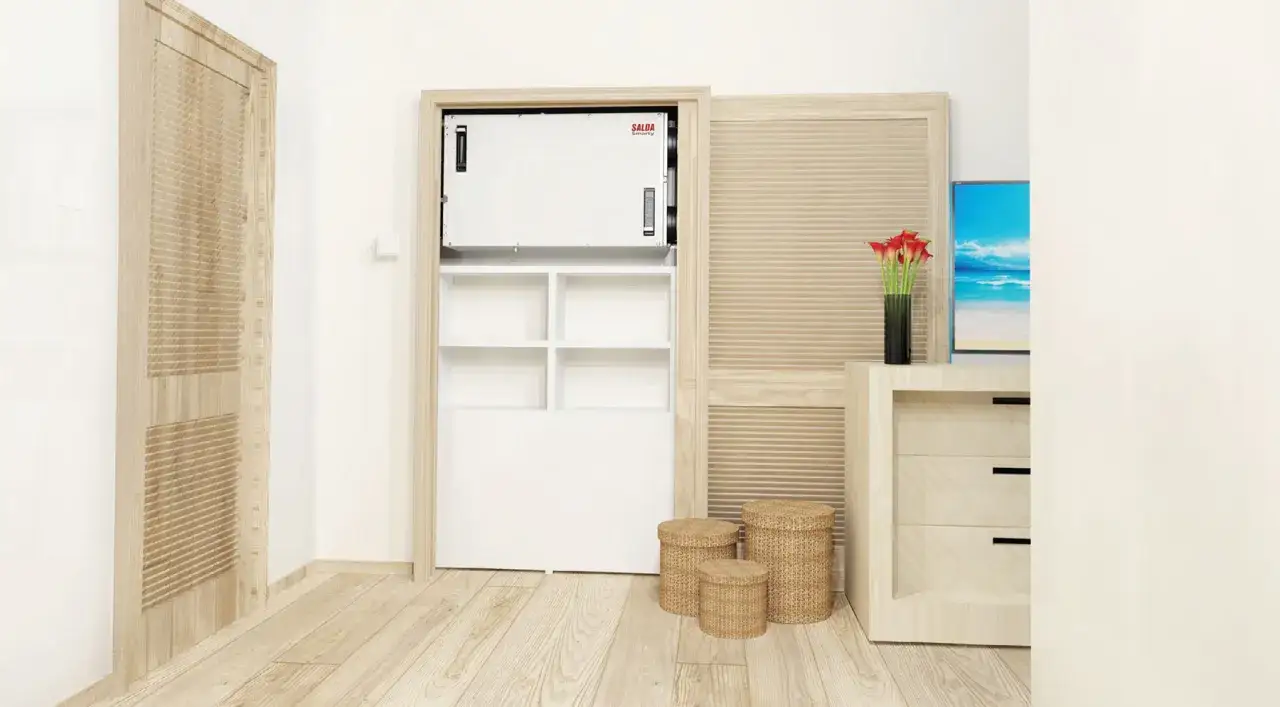 Urządzenie SALDA Smarty w szafie to spos&oacute;b, jak oczyscic powietrze w domu. W tle telewizor z widokiem na plażę.