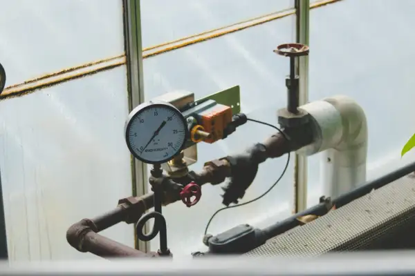 Manometr wskazuje prawidłowe ciśnienie w instalacji solarnej. Rury i zawory są częścią systemu.